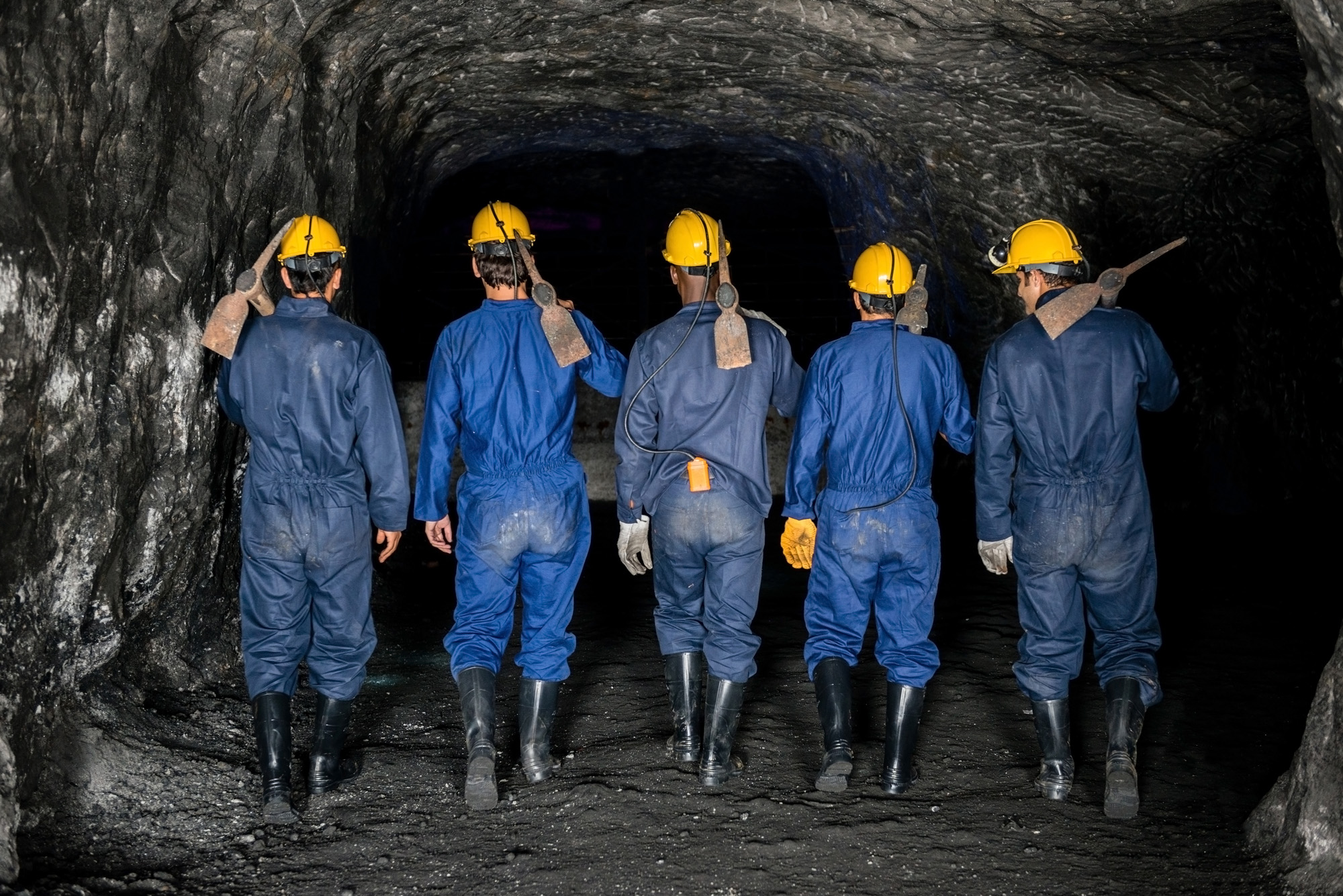 Back of a group of miners walking underground